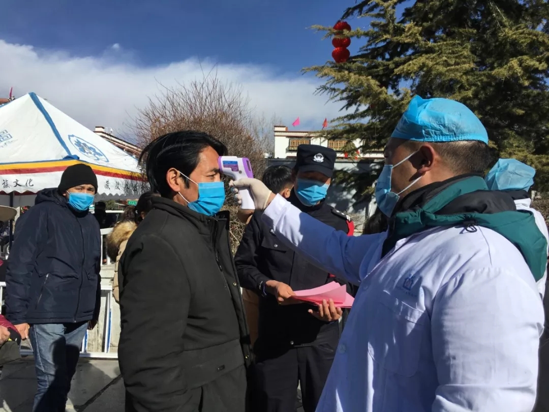 大昭寺广场安检入口工作人员给市民量体温以及发放传单。